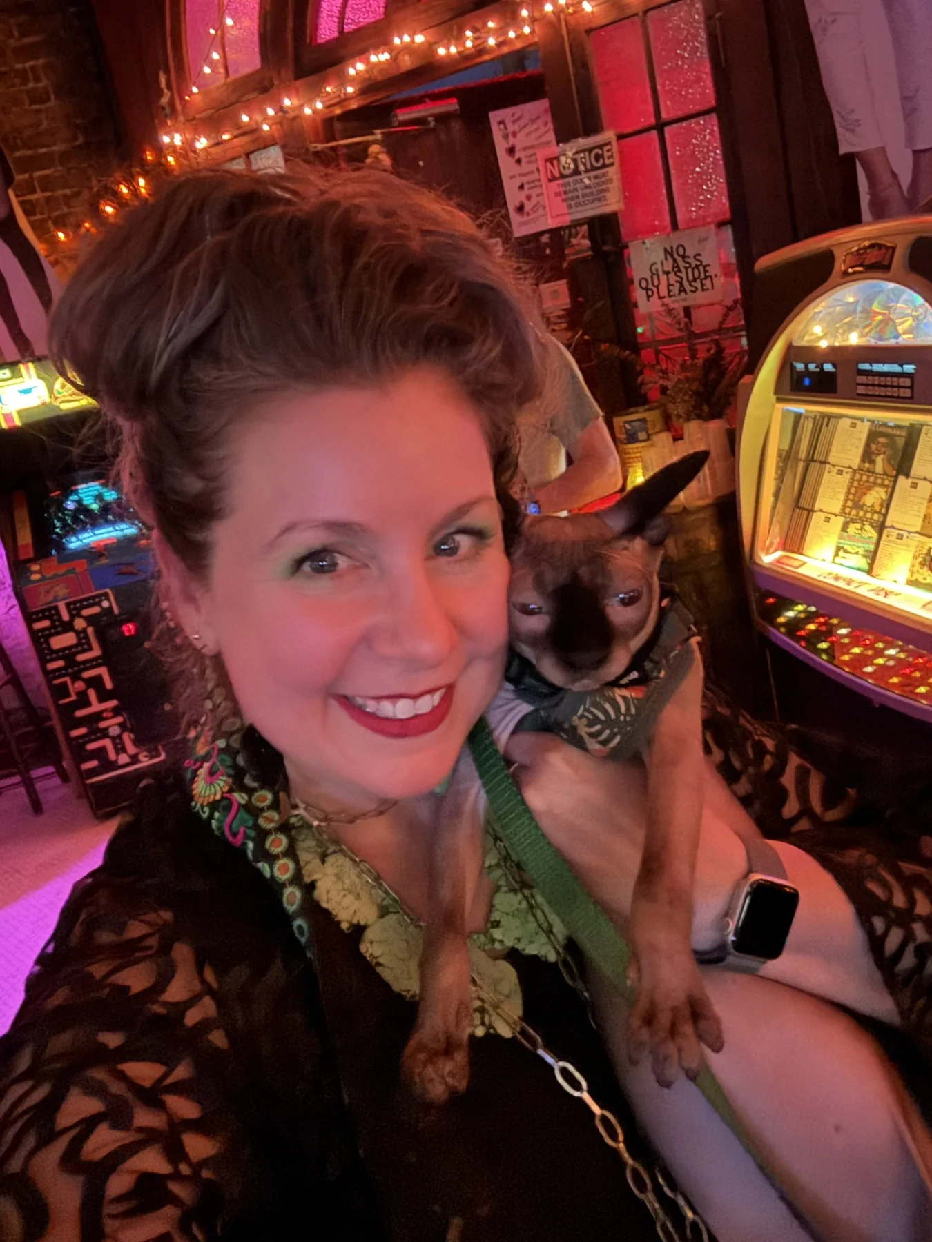 An adult smiling beside Harry in a warmly lit room with colorful decorations